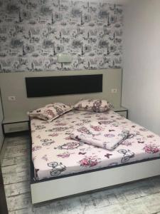 康斯坦察Andia的卧室内的一张床铺,配有花卉壁纸
