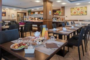 西尔米奥奈加德尼亚酒店的一间餐厅配有桌椅,提供食物