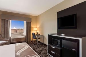珀尔Quality Inn & Suites Pearl-Jackson的配有一张床和一台平面电视的酒店客房