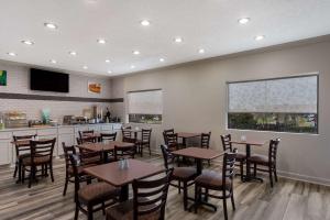珀尔Quality Inn & Suites Pearl-Jackson的一间带桌椅和柜台的餐厅