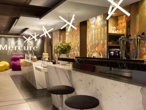 巴黎巴黎阿莱西亚美居酒店的餐厅的柜台上带两个凳子的酒吧