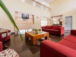 坎皮纳斯Ibis Styles Campinas Alphaville的客厅配有红色沙发和咖啡桌