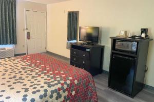 斯威特沃特Econo Lodge Inn & Suites Sweetwater I-20的酒店客房,配有床和电视