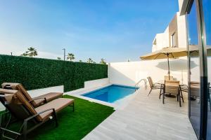 拉斯阿尔卡麦Luxury Villas with Beach Access by VB Homes的一个带桌椅的庭院和一个游泳池