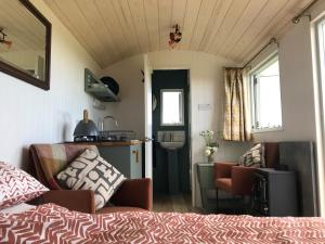 BreageEwe With A View Sea View Shepherds Huts的一间卧室配有一张床,厨房配有水槽