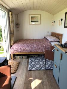 BreageEwe With A View Sea View Shepherds Huts的一间卧室配有两张床、一张桌子和一张沙发