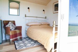 BreageEwe With A View Sea View Shepherds Huts的一间卧室配有一张床和一把椅子