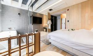 大邱Hotel Yeogiuhtte SeoDaegu的卧室配有一张白色大床和浴缸