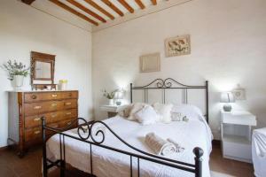 基安蒂盖奥勒Guest House il Gatto的一间卧室配有一张带白色床单的床和梳妆台。