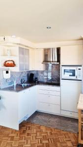 奥斯坦德Maui - zeezichtappartement te Oostende的厨房配有白色橱柜和微波炉