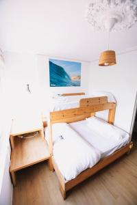 擞莫Latas Surf House的一间卧室配有两张双层床和一张书桌
