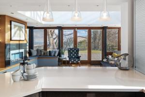 桑德斯富特Oaktree Lodge - Luxury Cottage, Hot Tub, Sea Views的一间带白色台面的厨房和一间客厅