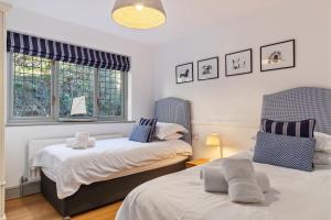 桑德斯富特Oaktree Lodge - Luxury Cottage, Hot Tub, Sea Views的一间卧室设有两张床和两个窗户。