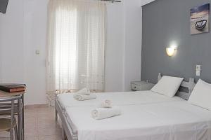 斯基亚索斯镇La Pensione Skiathos的一间卧室配有两张带毛巾的床