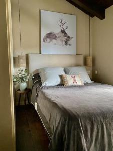 UrXalet Montana的卧室配有一张挂着鹿图的床铺。