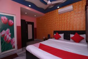 GauripurOYO Hotel Jagannath International Near Kolkata Airport的一间卧室配有一张带红色枕头的大床