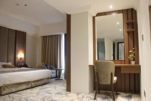 奥朱贝尔Hola Hotel的一间卧室配有一张床、一张书桌和一面镜子