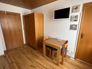 梅尔斯堡Pension Seliger的小房间设有一张桌子和墙上的电视