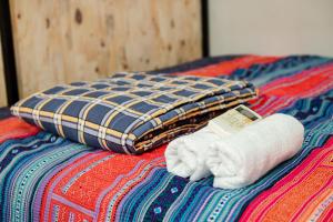 河江Rainbow House Ha Giang的床上的一大堆毛巾和枕头