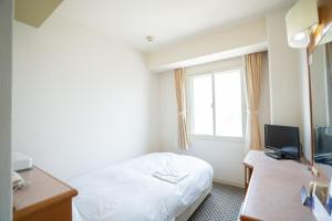 神户Hotel Casabella Inn Kobe的酒店客房设有床和窗户。