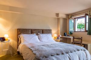 加维博吉奥加维Il住宿加早餐酒店的一间卧室配有一张带两张桌子和两个窗户的床。