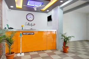 KharadiHotel Eon Inn Near Pune Airport的墙上挂着时钟的橙色门