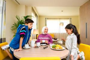 迪拜迪拜世贸中心诺富特酒店的一群坐在桌子旁吃食物的孩子