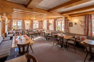 博尔斯特尔朗Riedbergerhorn - Gasthof & Ferienwohnungen的餐厅设有木桌、椅子和窗户。