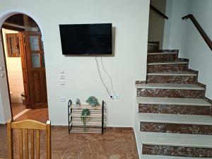 MantoúkionSavvas&Katia's luxury house的客厅设有楼梯,墙上配有平面电视。