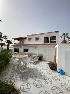 阿德耶Villa Tranquila, Playa del Duque的房屋前设有带桌椅的天井。