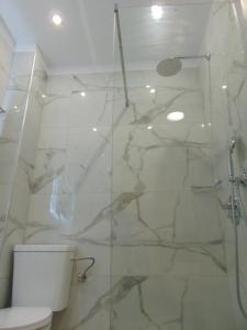 科斯镇Sweetmar Rooms-Ground floor的浴室设有玻璃淋浴间和卫生间