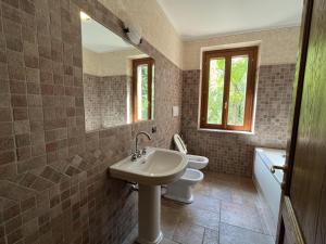 蒙赞巴诺Il borgo fra i laghi的一间带水槽、卫生间和镜子的浴室