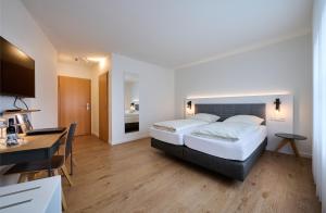SüdlohnHotel & Gasthaus Nagel的酒店客房配有两张床和一张书桌
