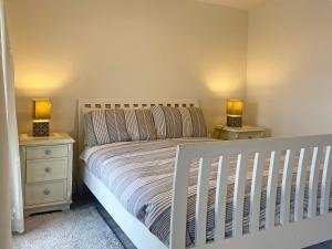朗德斯通Cottage 170 - Roundstone的一间卧室配有白色婴儿床和2个床头柜