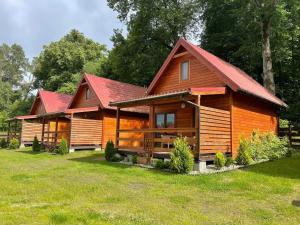 鲁恰内尼达Chaty Mazur w Wierzbie的大型木制小屋,设有红色屋顶