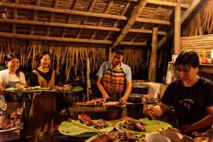 Pu LuongPuluong homestay1holiday的一群人站在桌子旁吃着食物