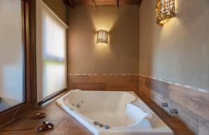 格拉玛多坎托维尔德酒店的带窗户的浴室设有大浴缸