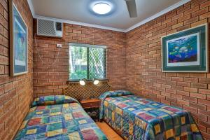 布鲁姆贝赛德假日公寓式酒店的一间设有两张床和砖墙的房间
