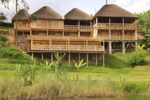 卡巴莱Keije Resort Bunyonyi的一座带茅草屋顶的大型木制建筑,位于山上