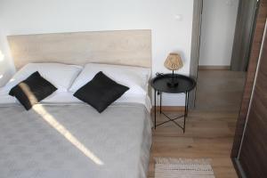 沃迪切Villa Branko的卧室配有白色的床、两个枕头和一张桌子