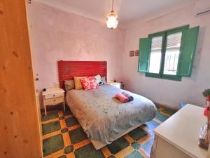 克莉丝蒂娜岛Casa Dos Mareas的一间卧室配有一张大床和红色床头板