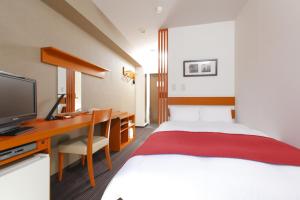 东京MYSTAYS 龟户酒店的酒店客房配有一张床和一张书桌及一台电视