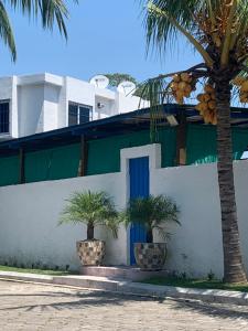 圣何塞港Chalet Casa Vacacional Riveras de Chulamar的白色的建筑,有蓝色的门和棕榈树