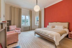 德哈恩Oceanide - Gerenoveerde luxe villa vlak bij het strand的一间卧室设有一张床和红色的墙壁