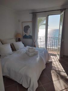 卡萨雷斯Frontline Beach Apartment, La Perla de la Bahia, Bahia de Casares - Estepona的一间卧室设有一张床,享有海景