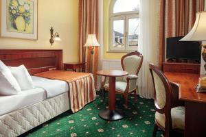 卡罗维发利洪堡公园及水疗酒店的配有一张床、一张桌子和一张桌子的酒店客房