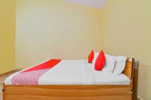 巴加OYO Royal Castle Near Baga Beach的一间卧室配有红色和白色枕头的床