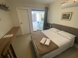 卡波布里奥Vila das Dunas - aluguel de temporada的一间卧室配有一张床,上面有两条毛巾