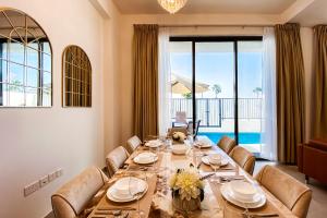 拉斯阿尔卡麦Luxury Villas with Beach Access by VB Homes的一间带长桌和椅子的用餐室