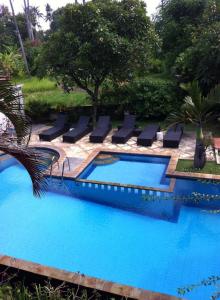 罗威那贾耶旅馆的毗邻度假酒店的带躺椅的游泳池